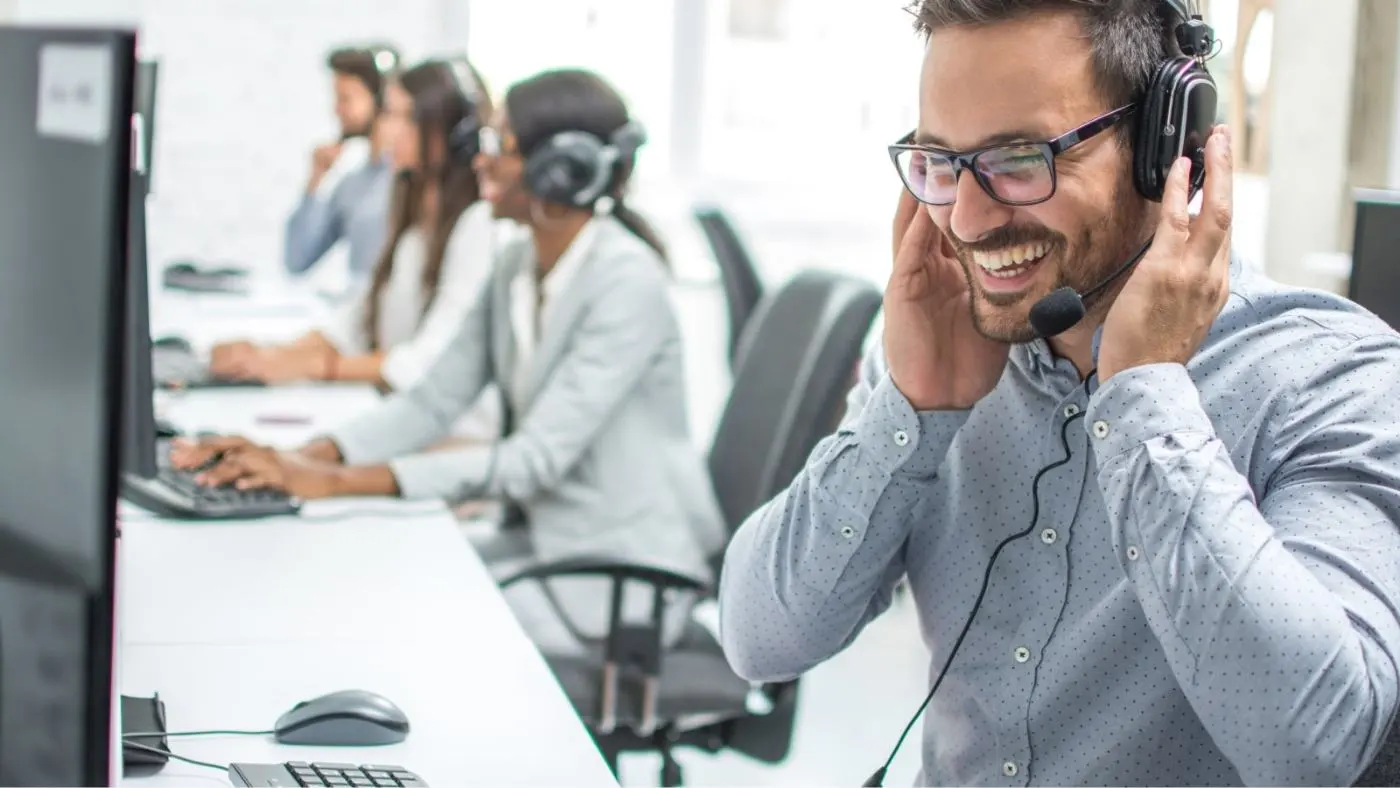 Un uomo è al telefono in ufficio con le cuffie.