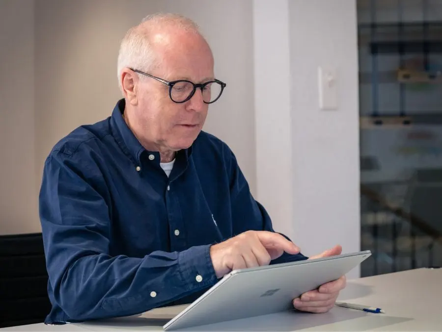 Un uomo del team di future-cube lavora intensamente su un tablet.