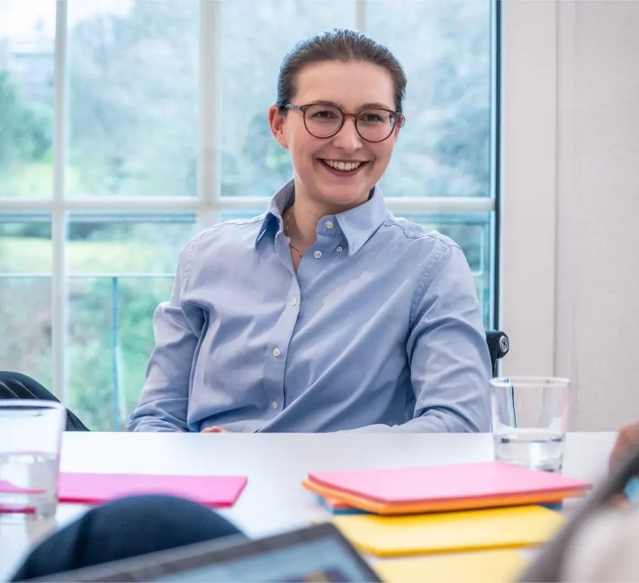 Immagine di una donna sorridente con gli occhiali durante un workshop.